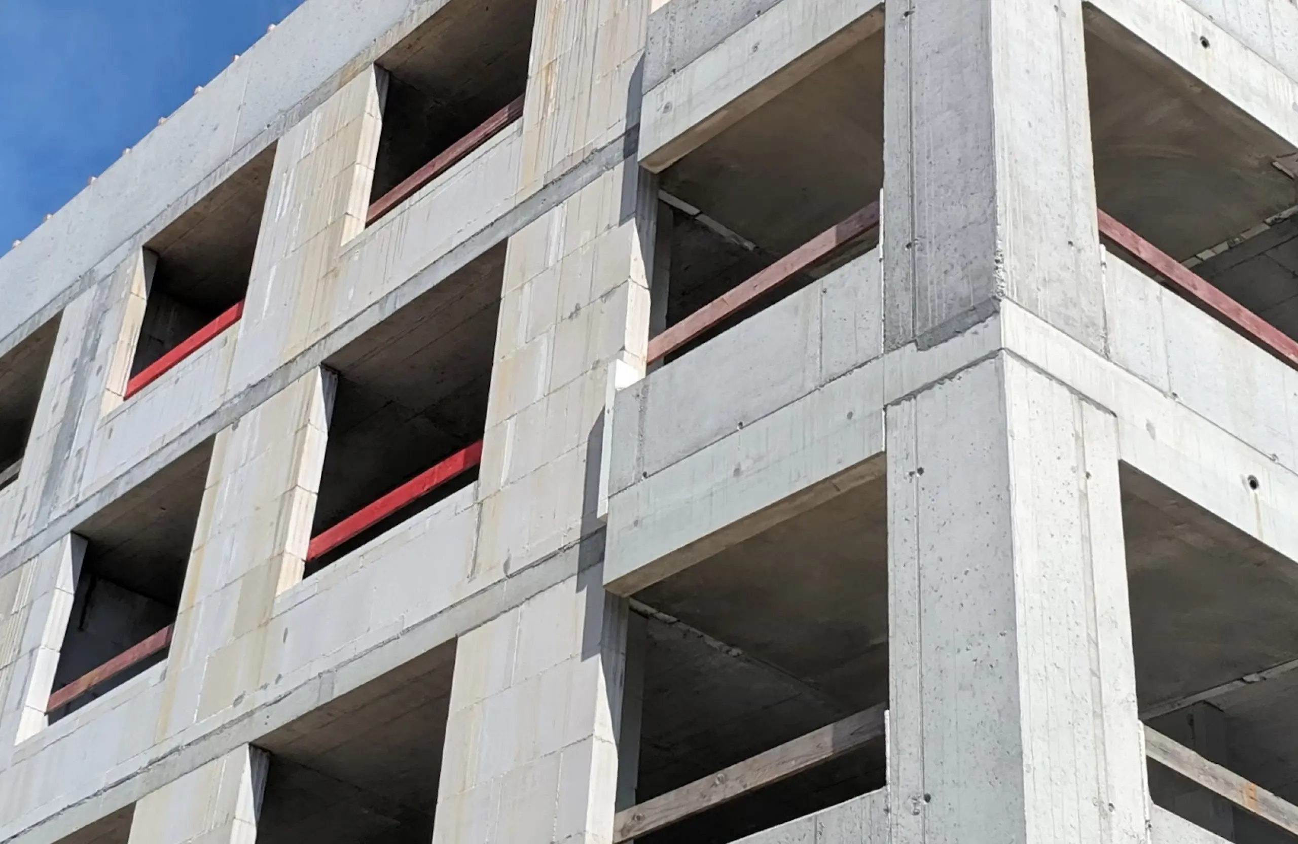 Stone Haven Developments A concrete building under construction, with unfinished balconies and exposed floors visible against a clear blue sky. Ontario