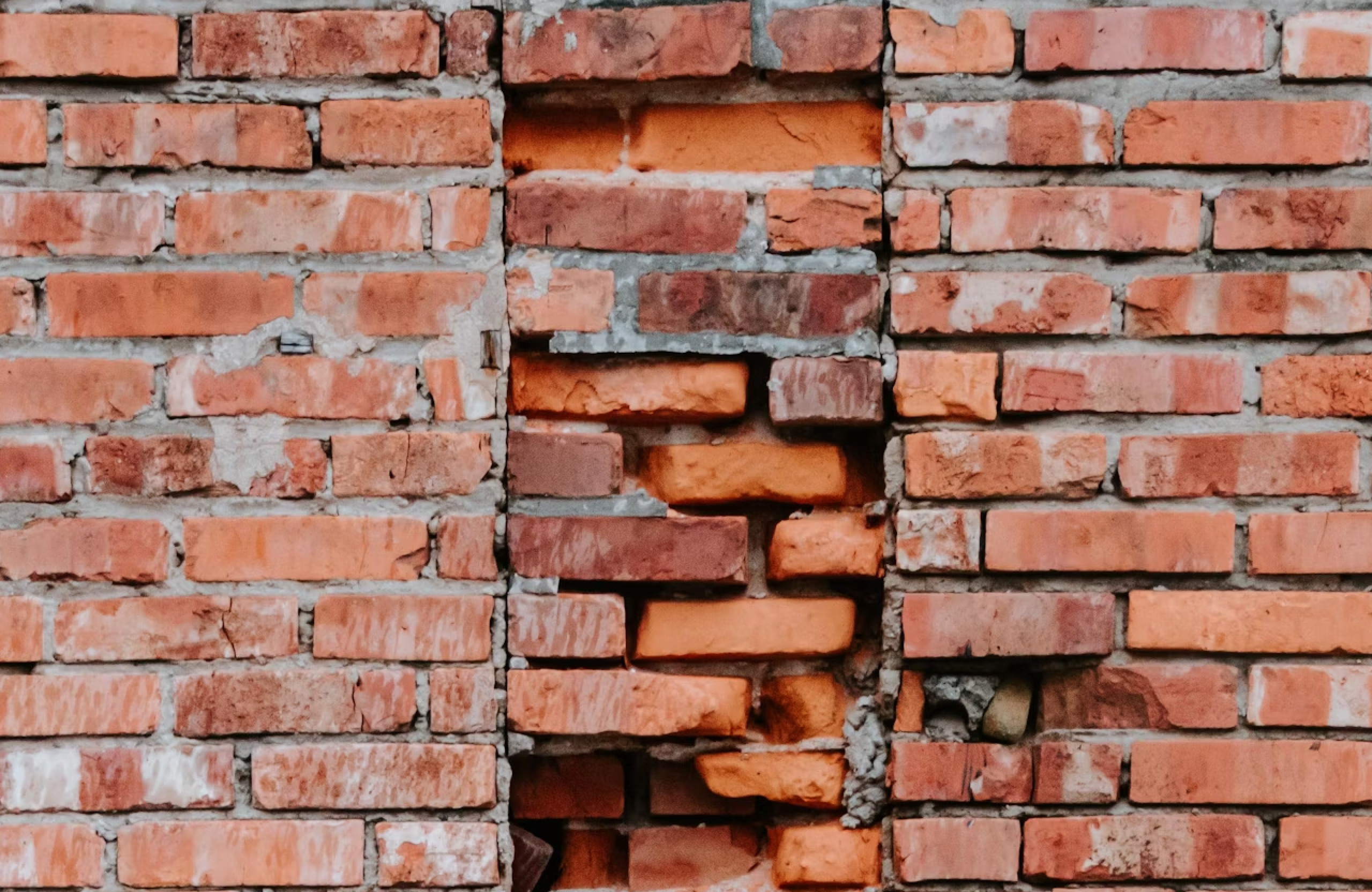 Stone Haven Developments A brick wall section with uneven and misaligned bricks, showing visible gaps and irregular placement compared to the rest of the wall. Ontario